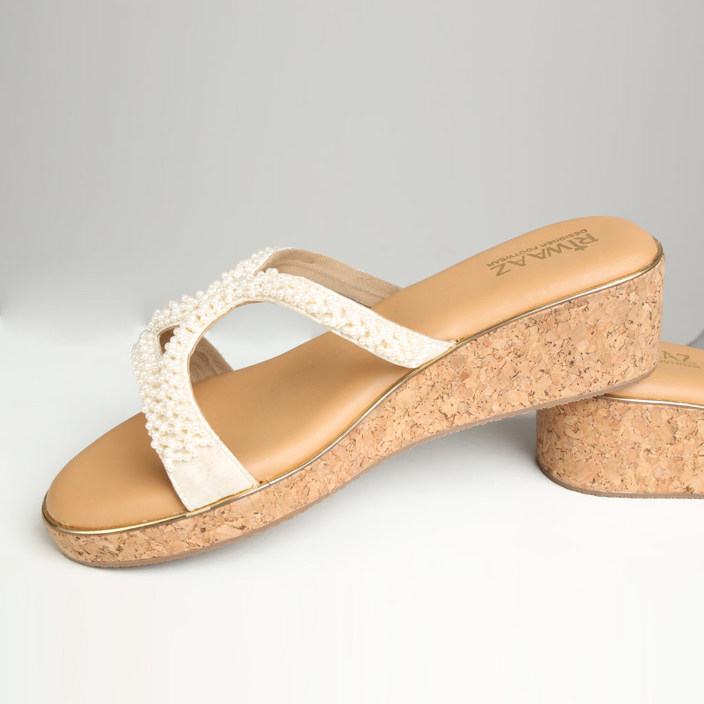 Model wearing Riwaaz Pearl Royale dark beige pearl crossover cork wedge sandals with white chikankari dress
