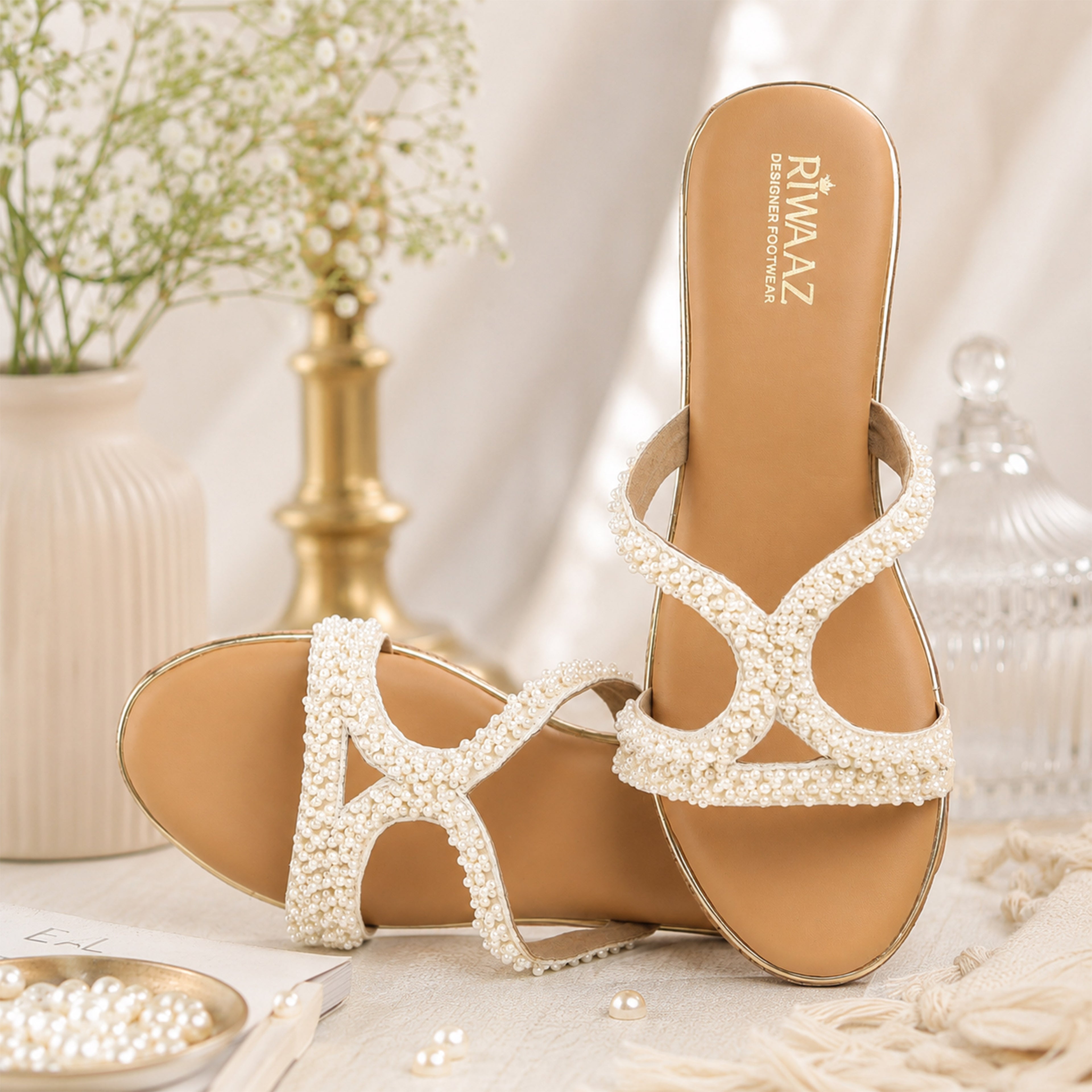Close-up of model wearing Riwaaz Pearl Royale cork wedge sandals with pearl crossover straps and white ethnic wear