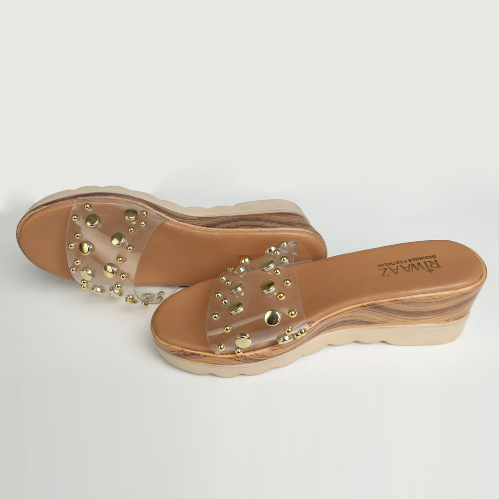 Riwaaz Nora dark beige gold stud transparent strap wedge slides – angled product shot showing stud detail and cushioned footbed
