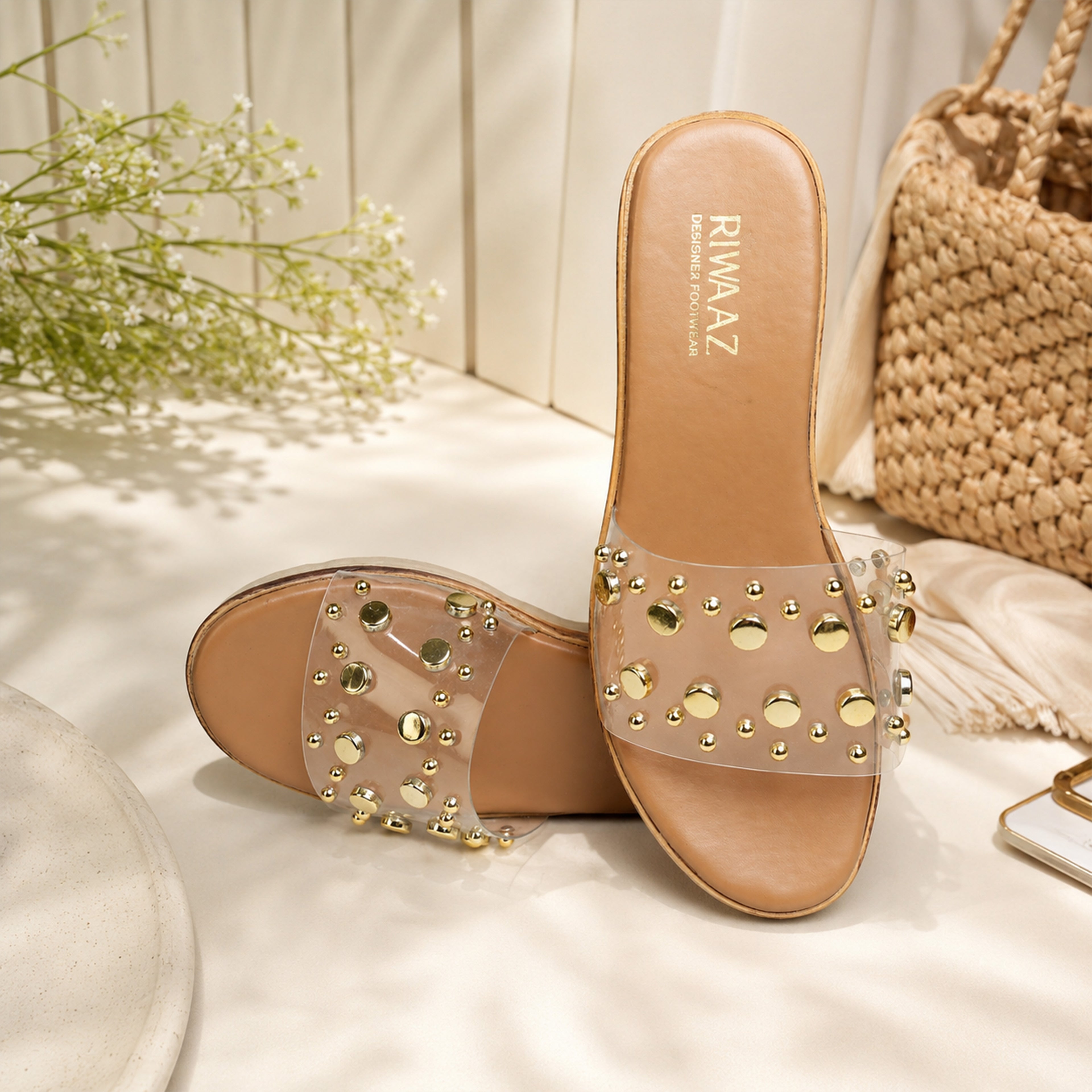 Model seated in white ethnic wear wearing Riwaaz Nora dark beige gold stud clear strap wedge slides – lifestyle shot