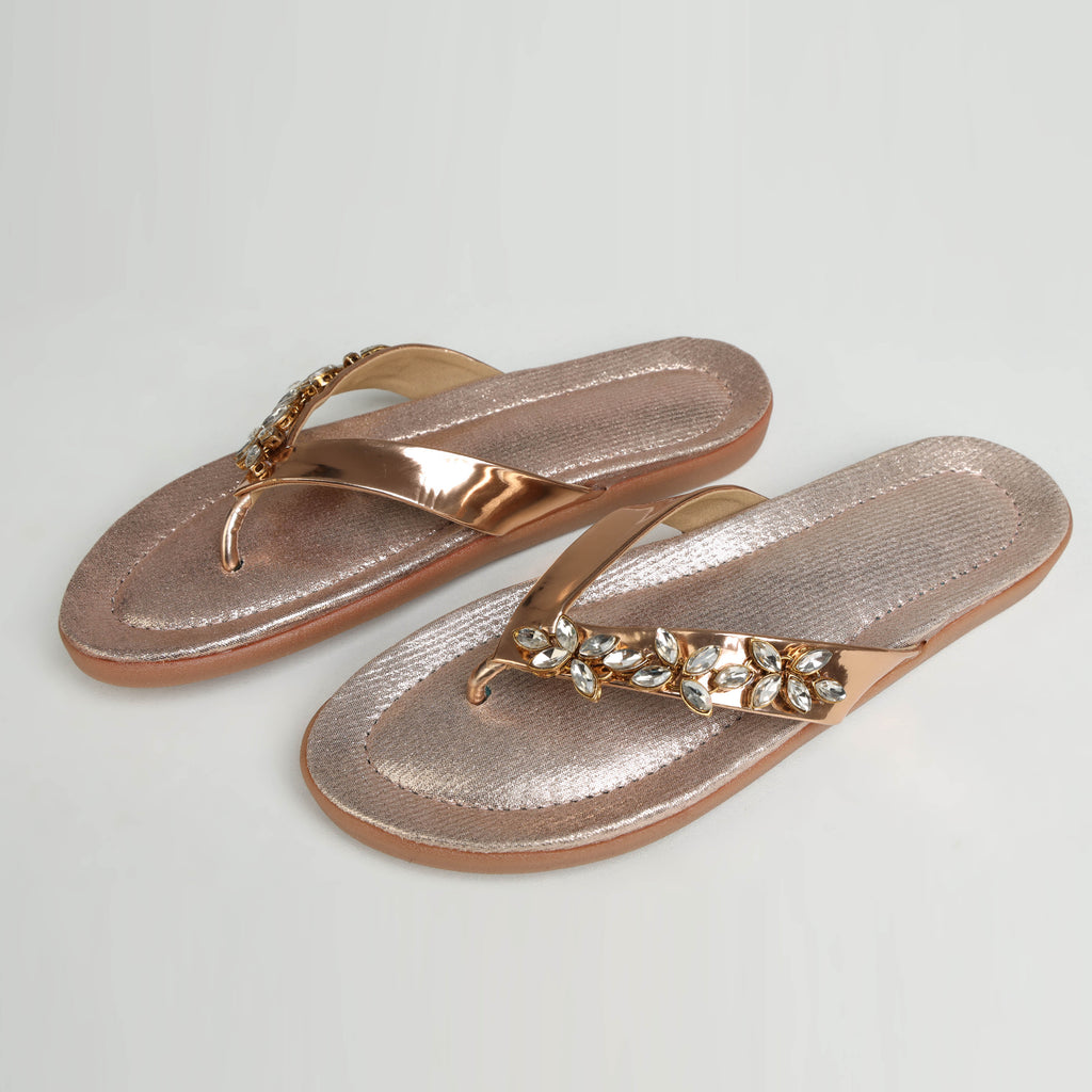 Dull rose gold Riwaaz Ziva Kundan embellished flip flop with metallic gold strap and sparkling crystal cluster embellishment – product shot on white background with grey fabric