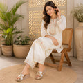 Pair of Riwaaz Gulnaar bead embroidered wedge slides on grey background – side angle showing wedge height and cushioned footbed