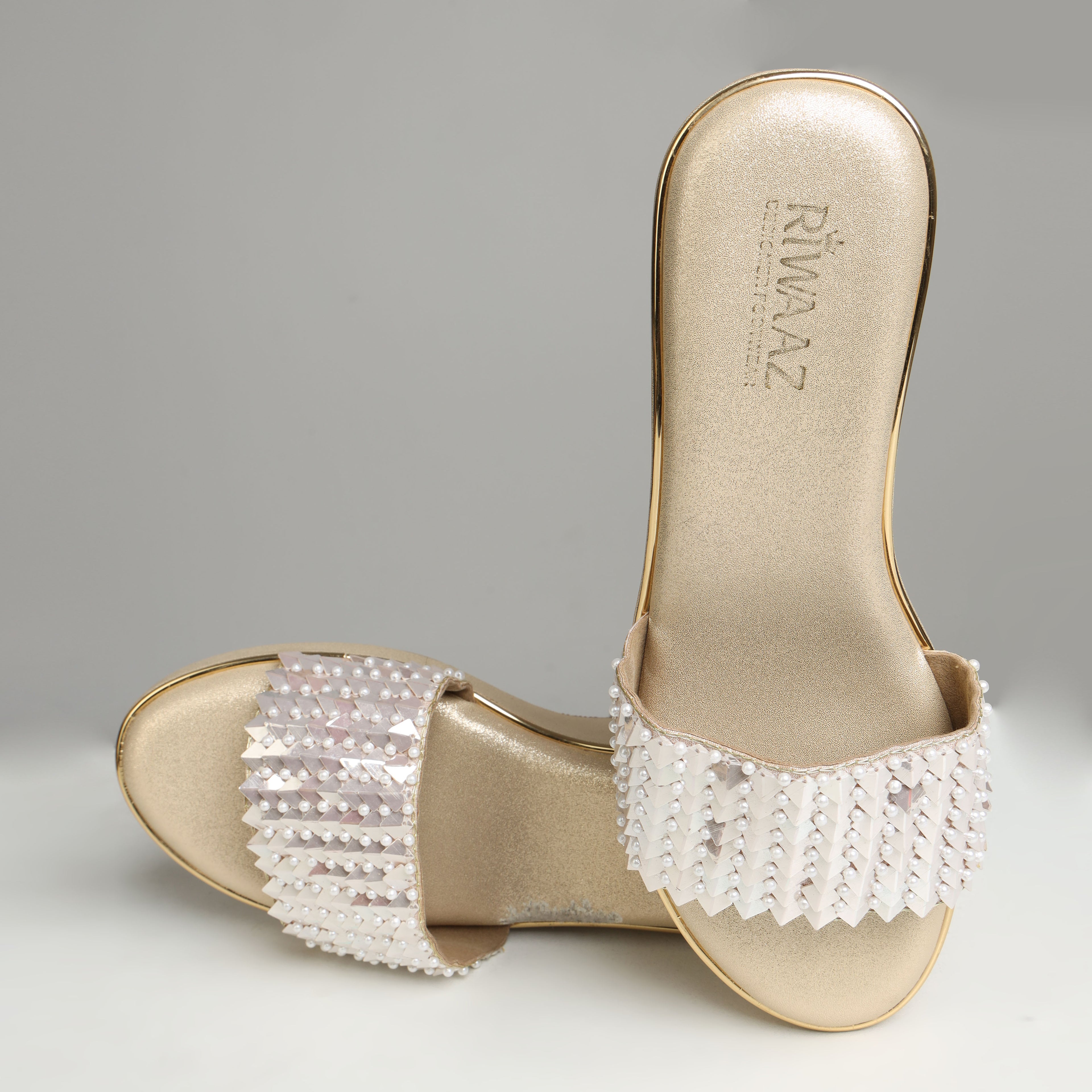 Pair of Riwaaz Chandni Glow dull gold wedge sandals on white background – angled front view showing full pearl and sequin strap embellishment and platform sole