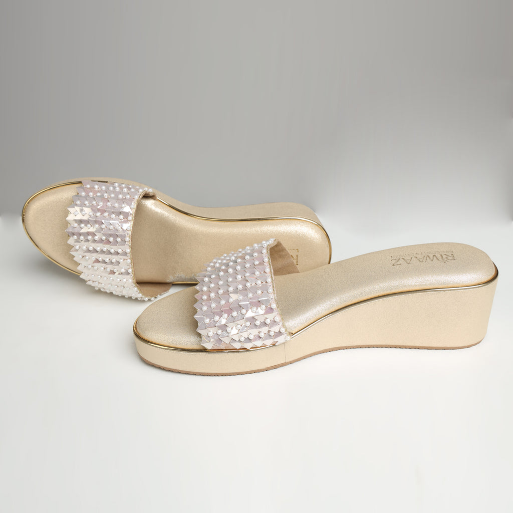 Pair of Riwaaz Chandni Glow dull gold wedge sandals on white background – three-quarter view showing wedge height and pearl sequin strap detail from above
