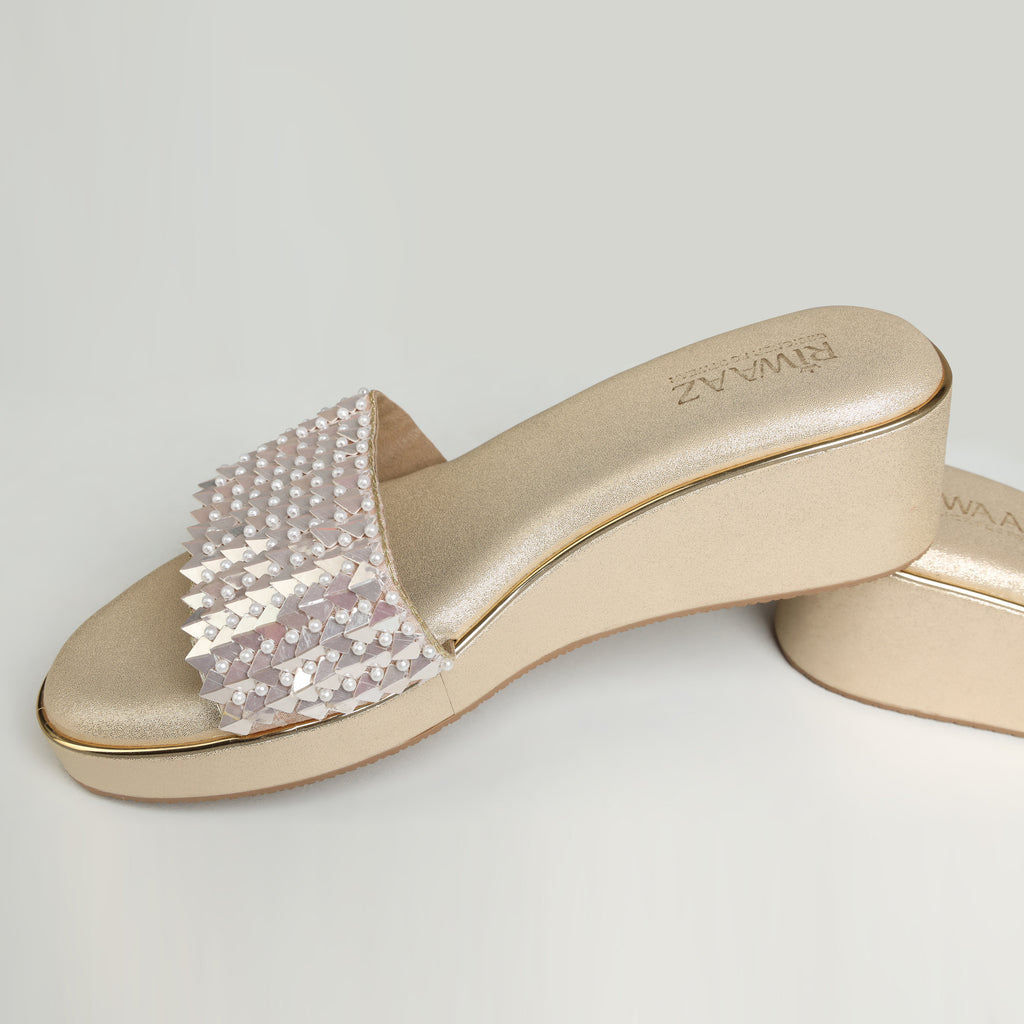 Pair of Riwaaz Chandni Glow dull gold wedge sandals – angled product shot on white background showing cushioned footbed and full pearl and sequin strap coverage