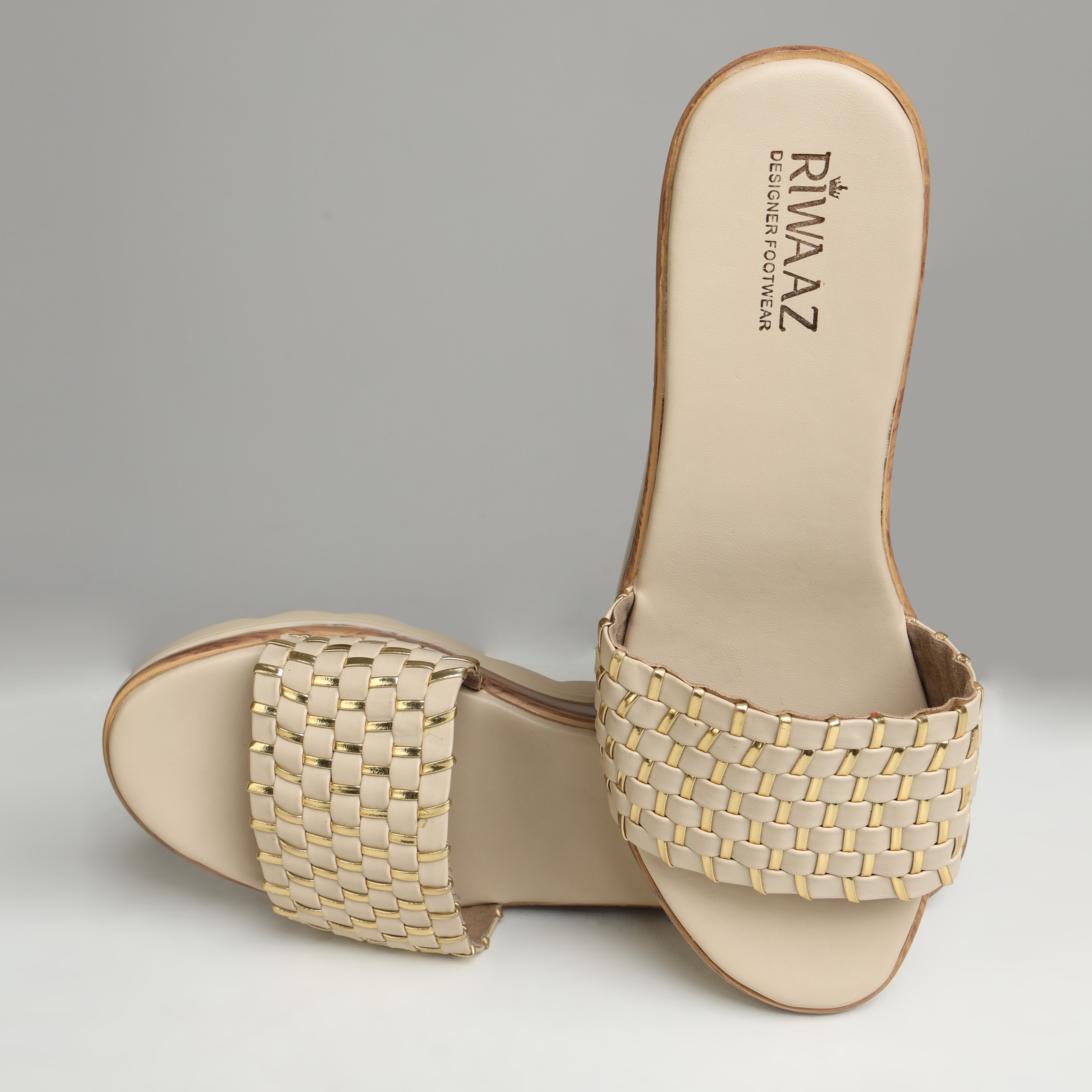 Pair of Riwaaz Ava cream woven metallic slides on white background – angled front view showing full woven strap and platform sole from above