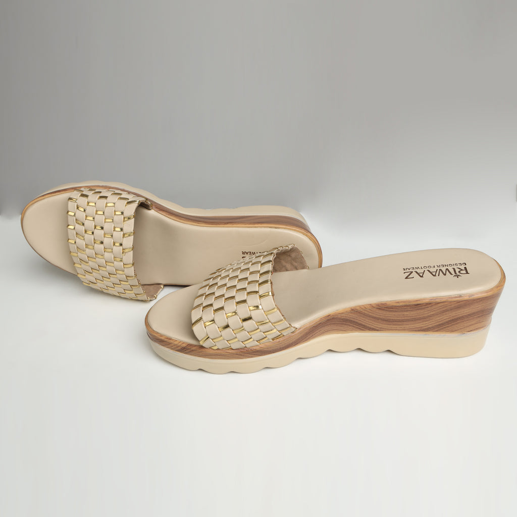 Pair of Riwaaz Ava cream woven platform slides on white background – three-quarter view showing wedge height and woven strap with gold metallic accent