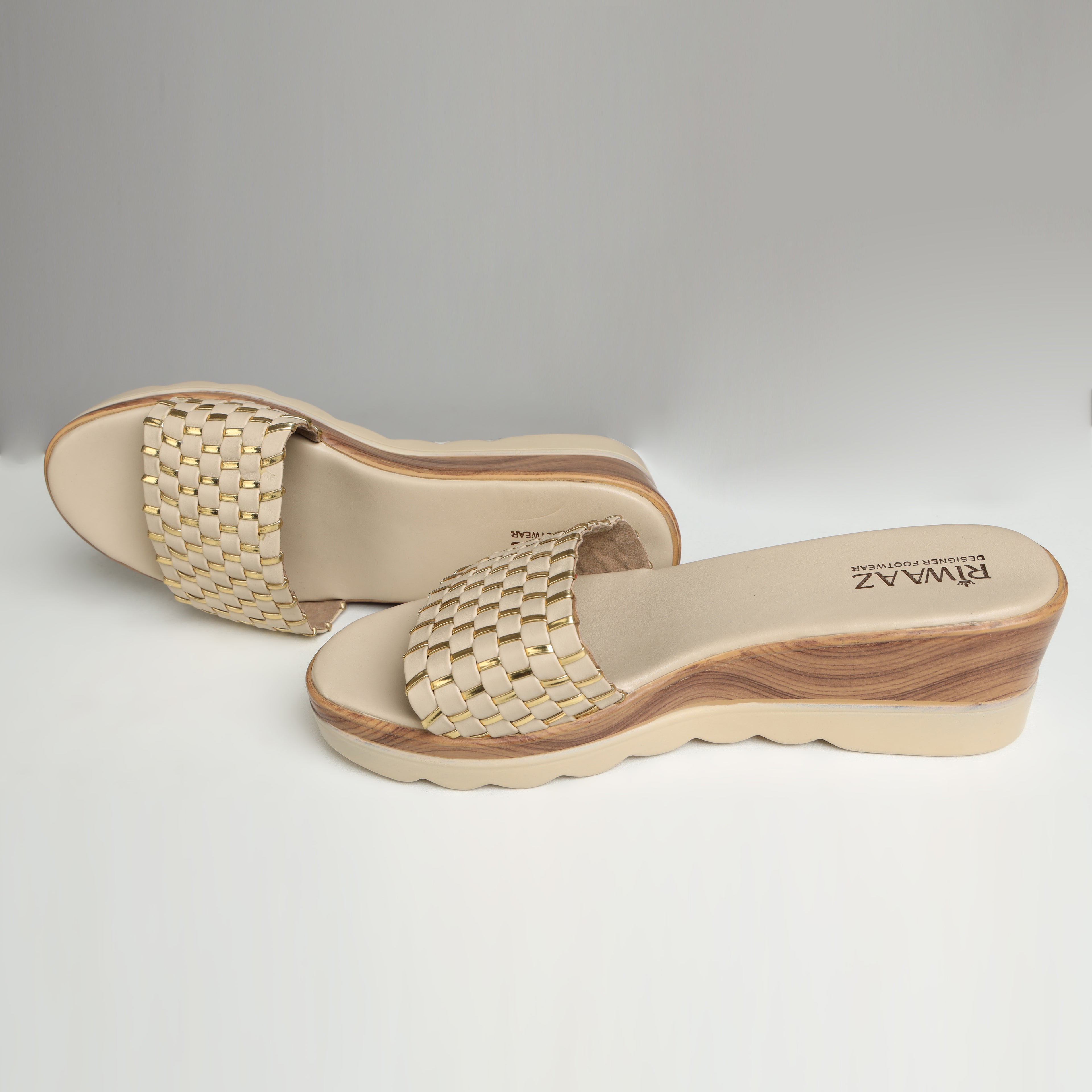 Pair of Riwaaz Ava cream woven platform slides on white background – three-quarter view showing wedge height and woven strap with gold metallic accent