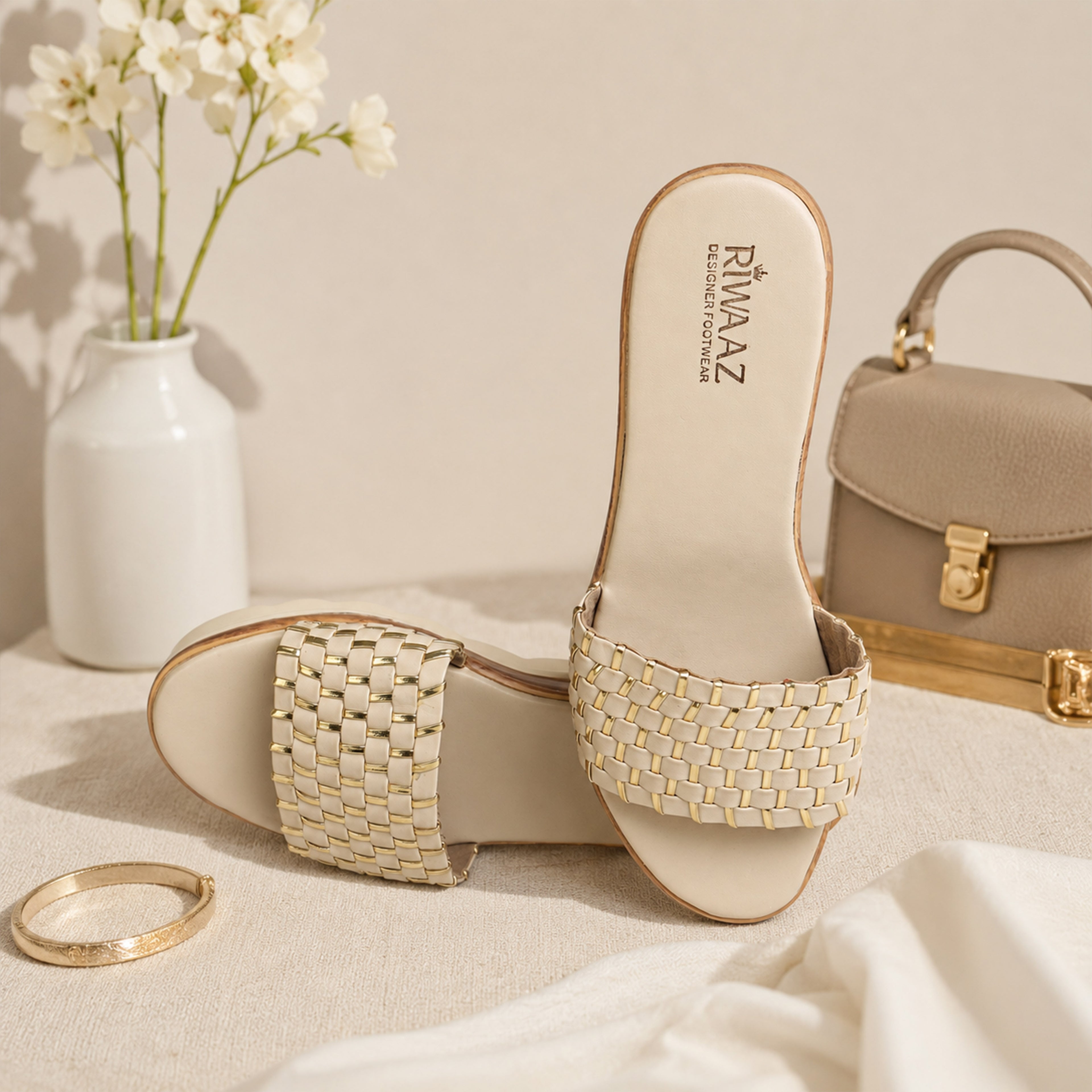 Model seated in cream embroidered kurta set wearing Riwaaz Ava cream woven platform slides – full lifestyle shot in elegant neutral interior with rattan chair and dried flowers