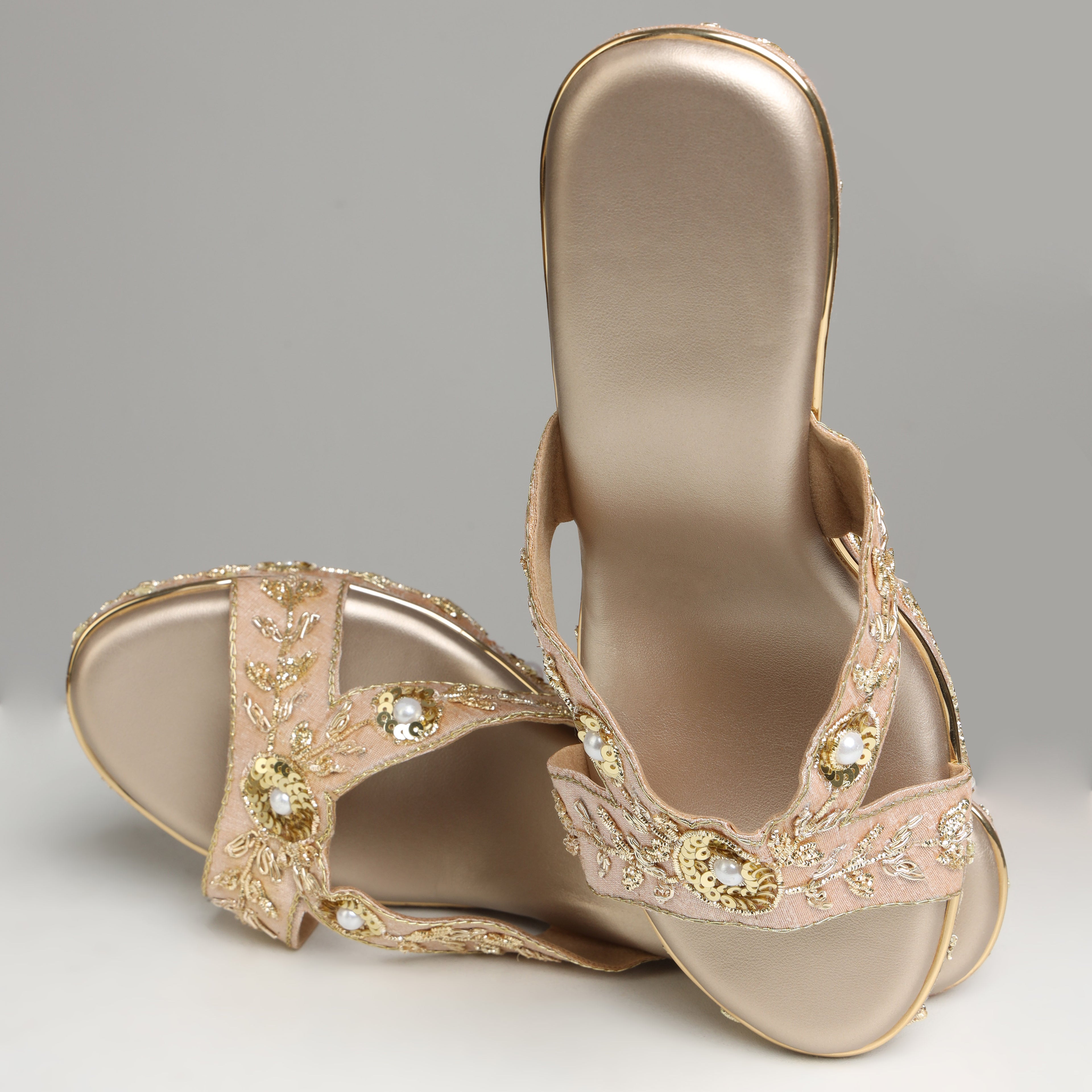Pair of Riwaaz Noor rose gold bridal wedge heels on white background – three-quarter front view showing cross-strap with pearl and sequin embellishment and embroidered platform
