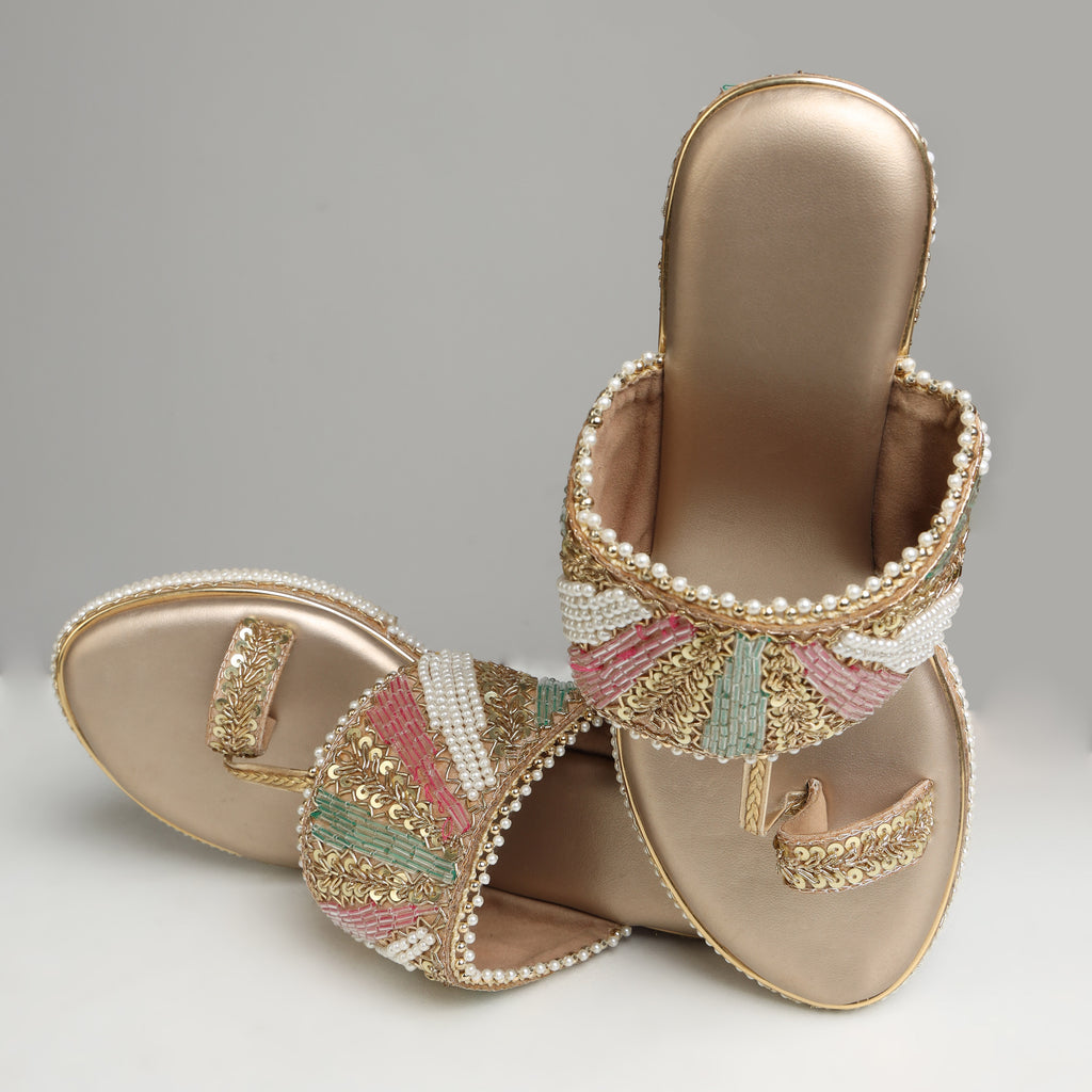Pair of Riwaaz Meher dull rose gold bridal block heel sandals on white background – three-quarter front view showing toe-ring detail, multicolour beaded strap and pearl-edged platform sole