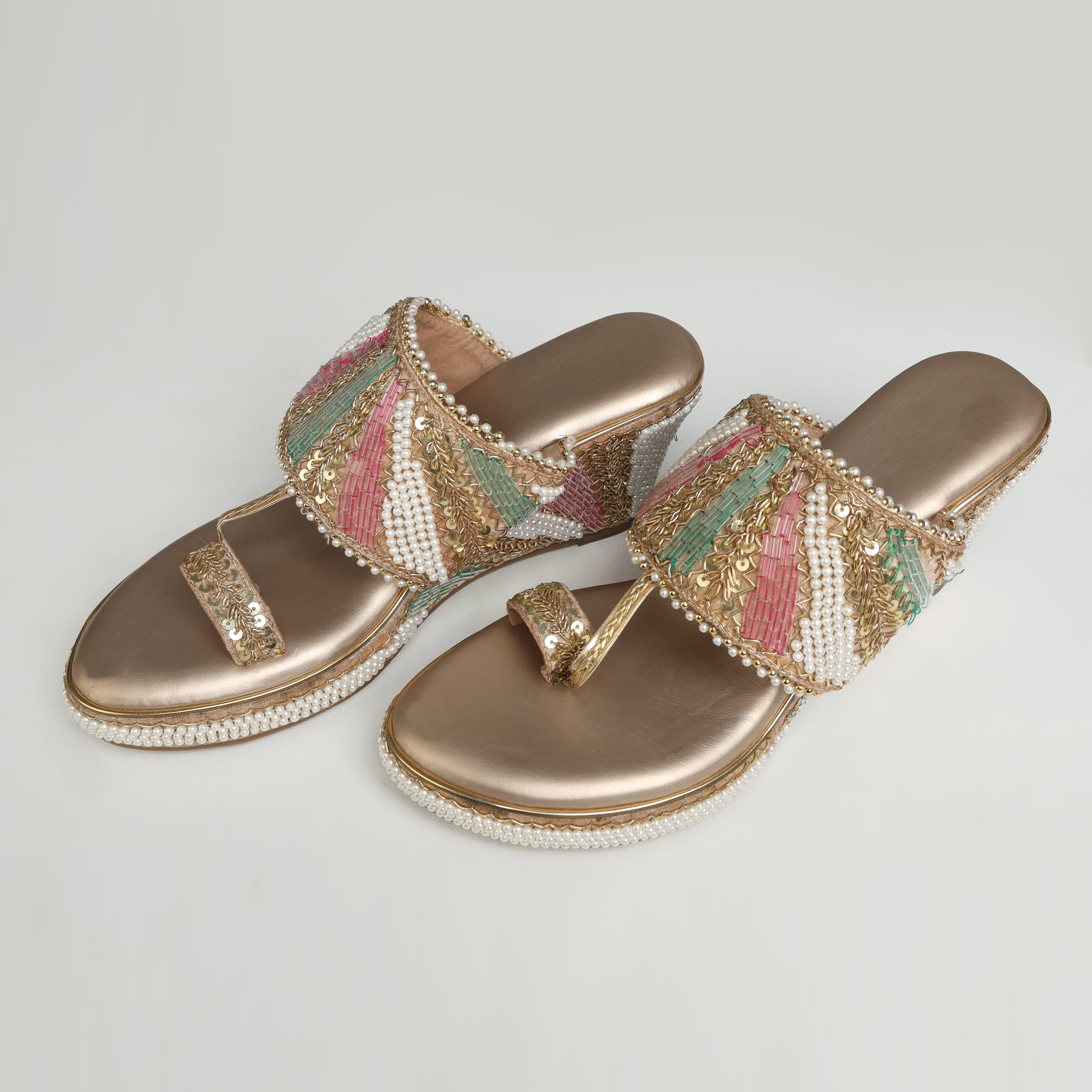Pair of Riwaaz Meher dull rose gold bridal block heel sandals – top-down product shot on white background showing champagne gold insole, toe-ring and full multicolour pearl-embellished Nalli embroidered strap