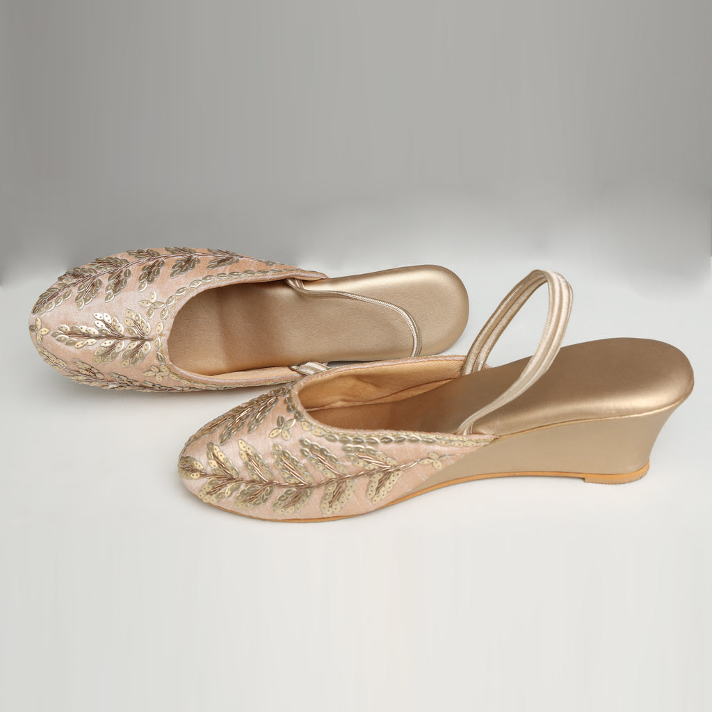 Pair of Riwaaz Zehra dull gold sequin leaf embroidered slingback wedge mules – top-down product shot on white background showing gold cushioned insole, double satin back strap and full sequin leaf embroidered upper