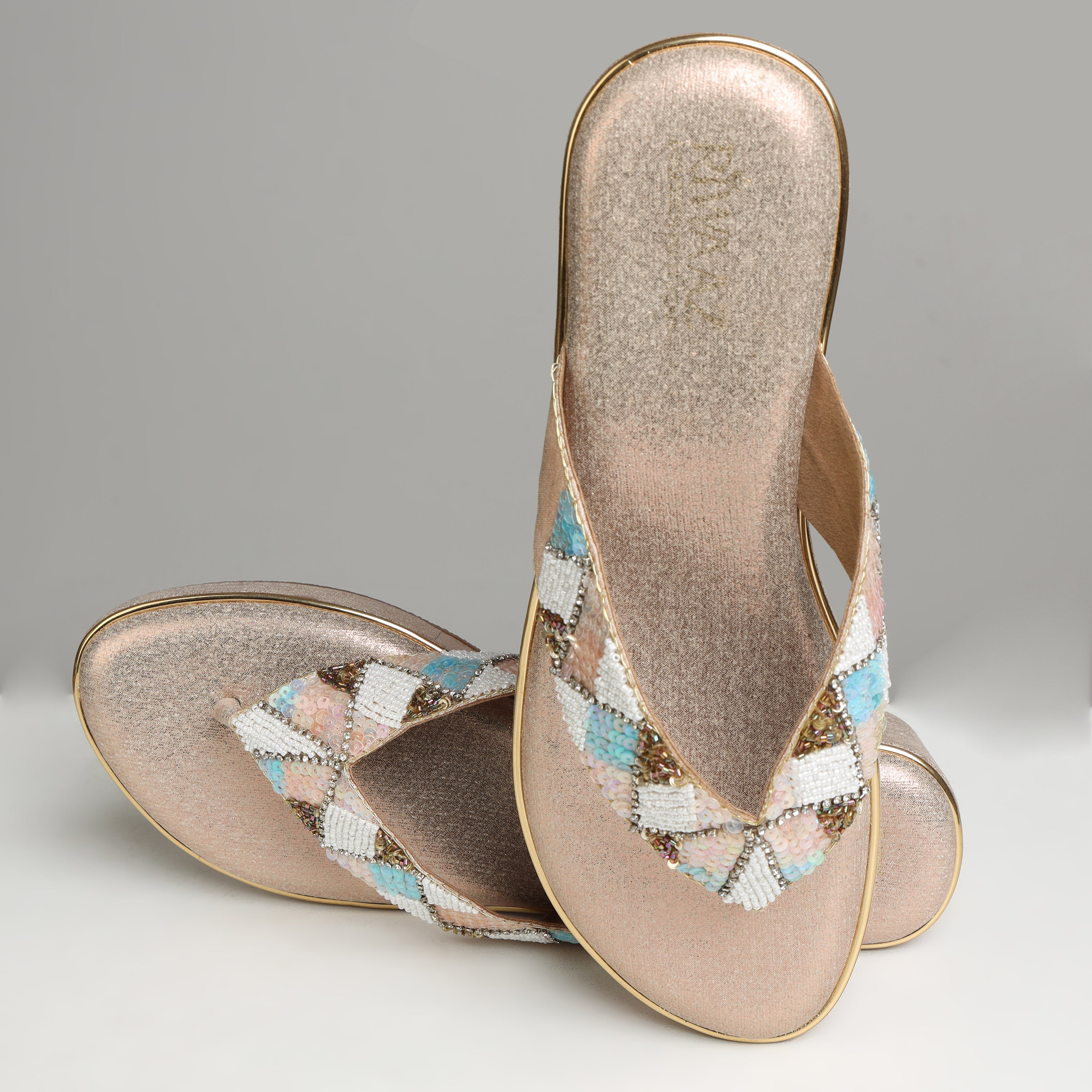 Pair of Riwaaz Afreen dull rose gold pastel geometric beaded thong wedge platforms on white background – three-quarter front view showing full pastel diamond beadwork pattern with pearl and sequin accents on rose gold base