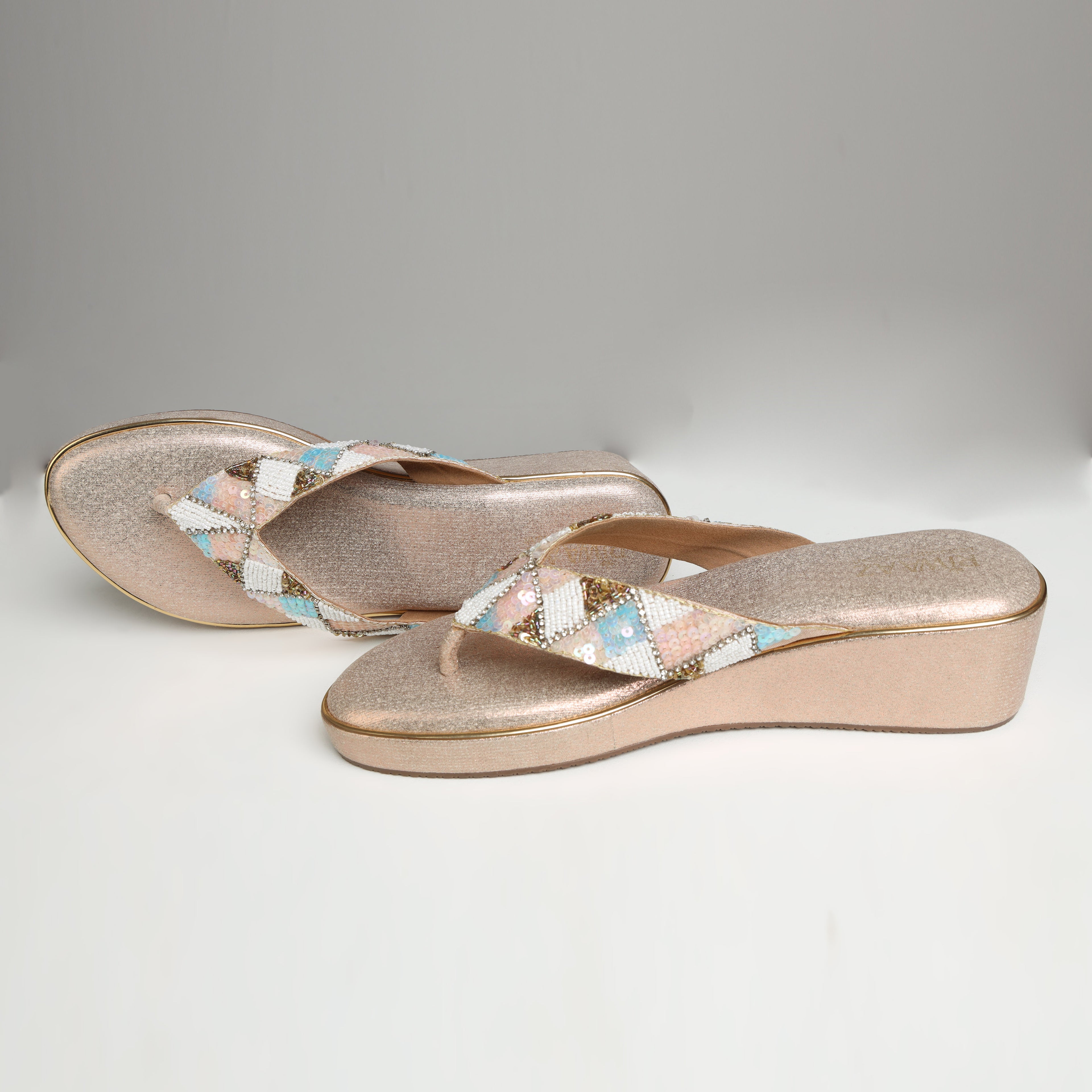 Pair of Riwaaz Afreen dull rose gold pastel geometric beaded thong wedge platforms on white background – angled top view showing shimmer rose gold insole and full geometric beaded thong strap with mint, blush and white diamonds